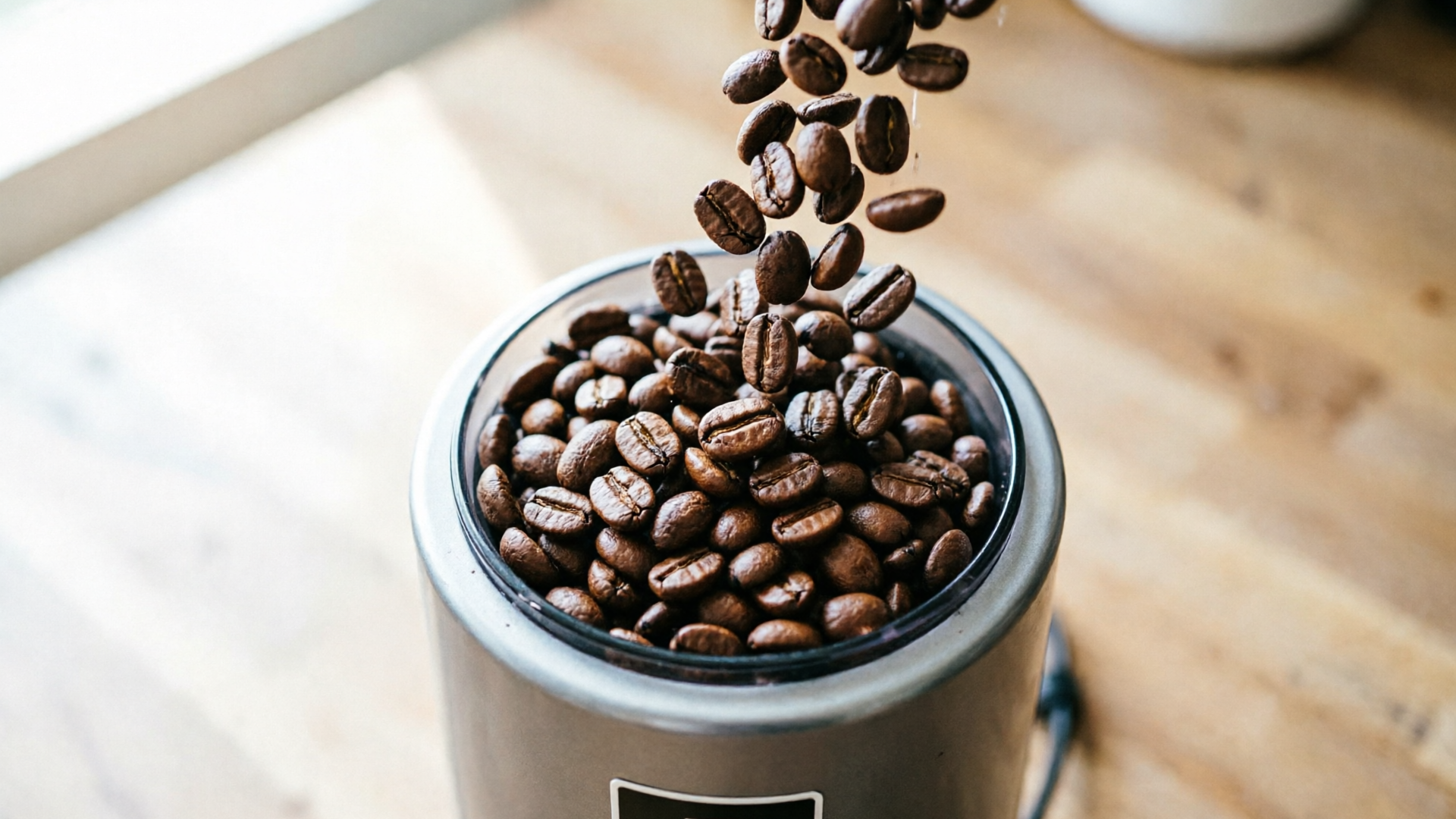 Top-down coffee beans pouring into grinder, motion captured