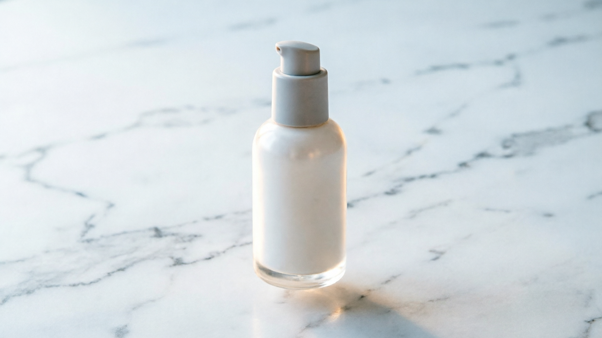 Tight vertical crop of a cosmetic bottle on marble