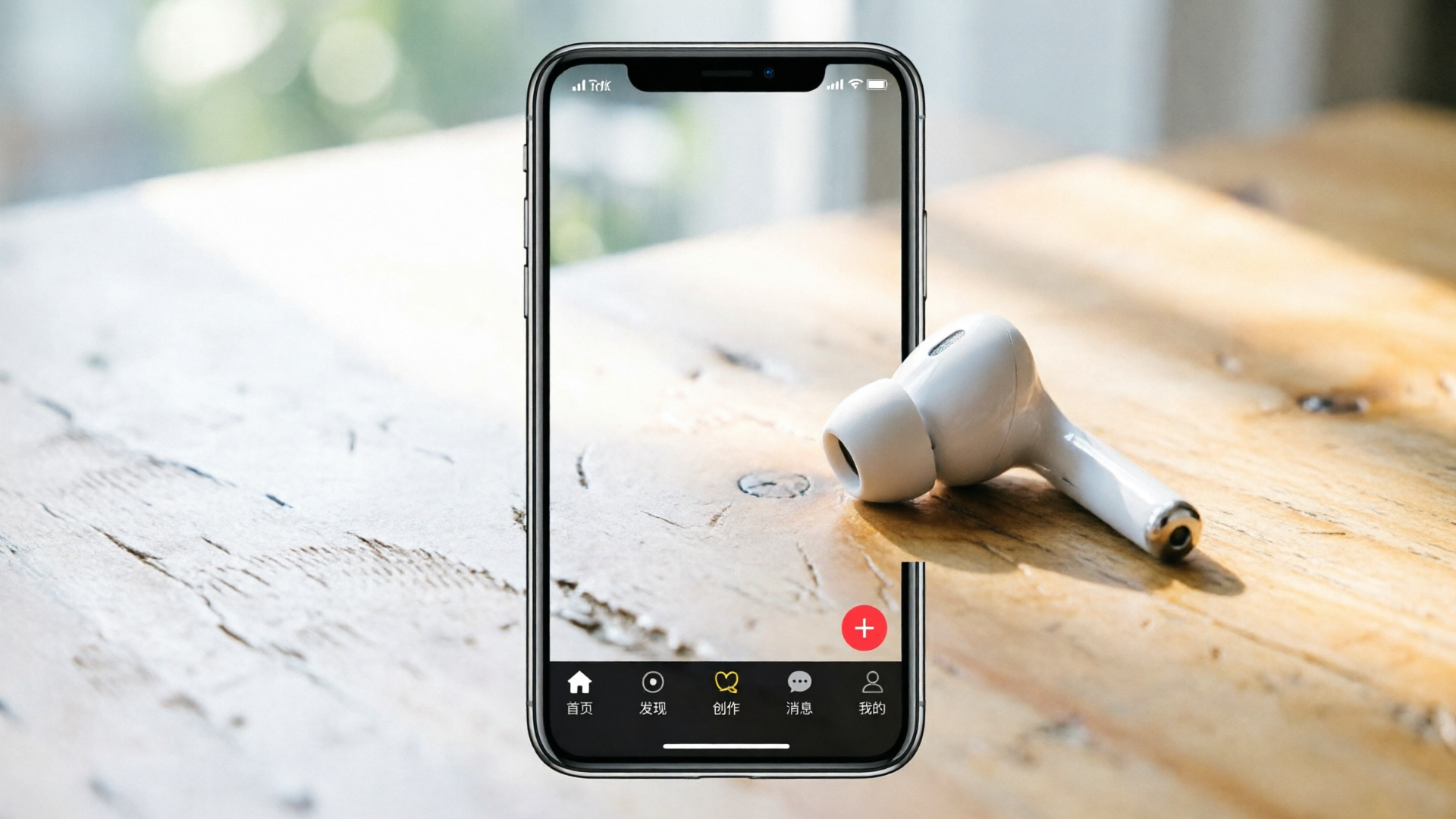 Phone playing short-form clip beside earbud on table